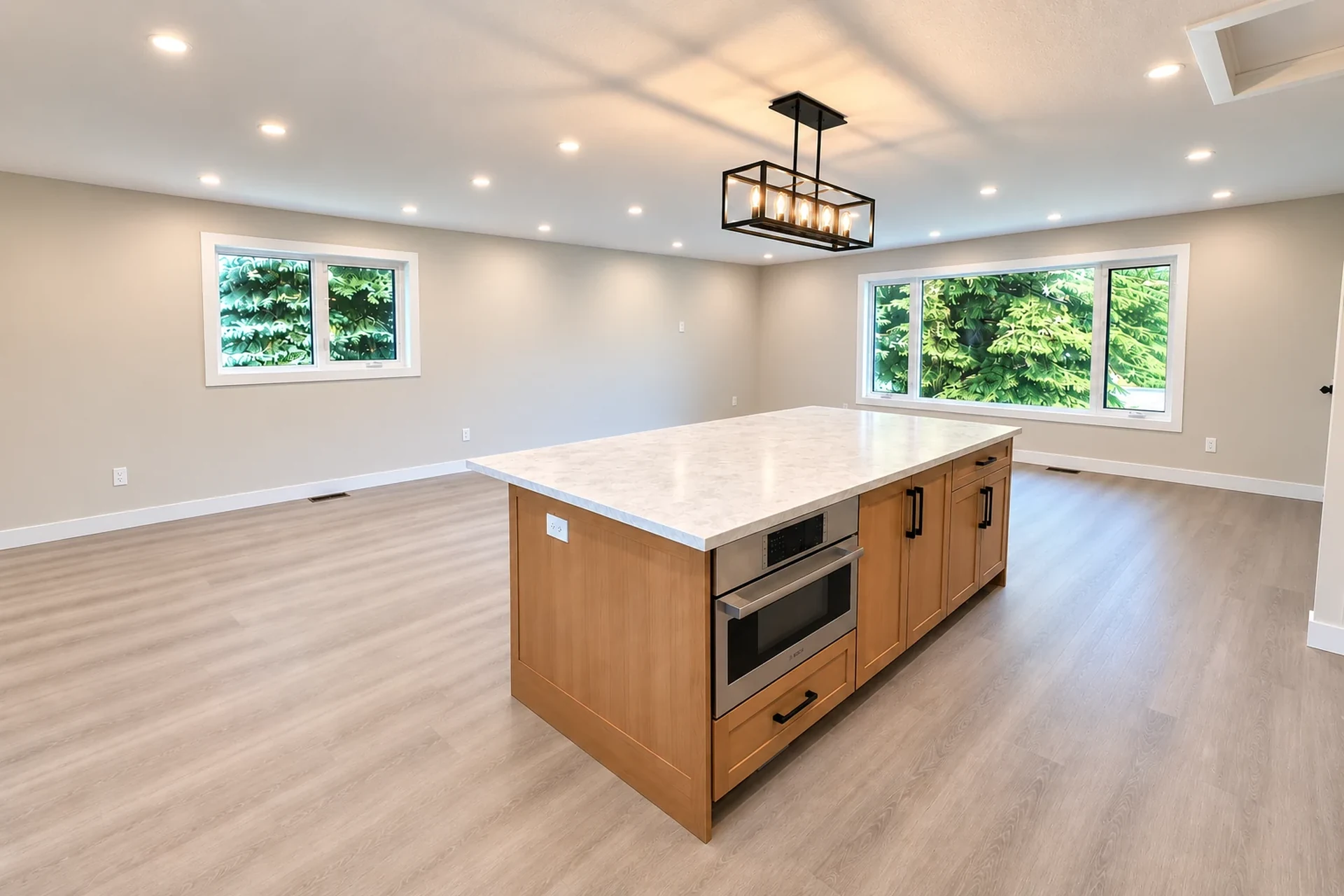 Lighting and electrical upgrades by UpRight Reno in Calgary, featuring recessed ceiling lights and modern pendant lighting in an open-concept space.